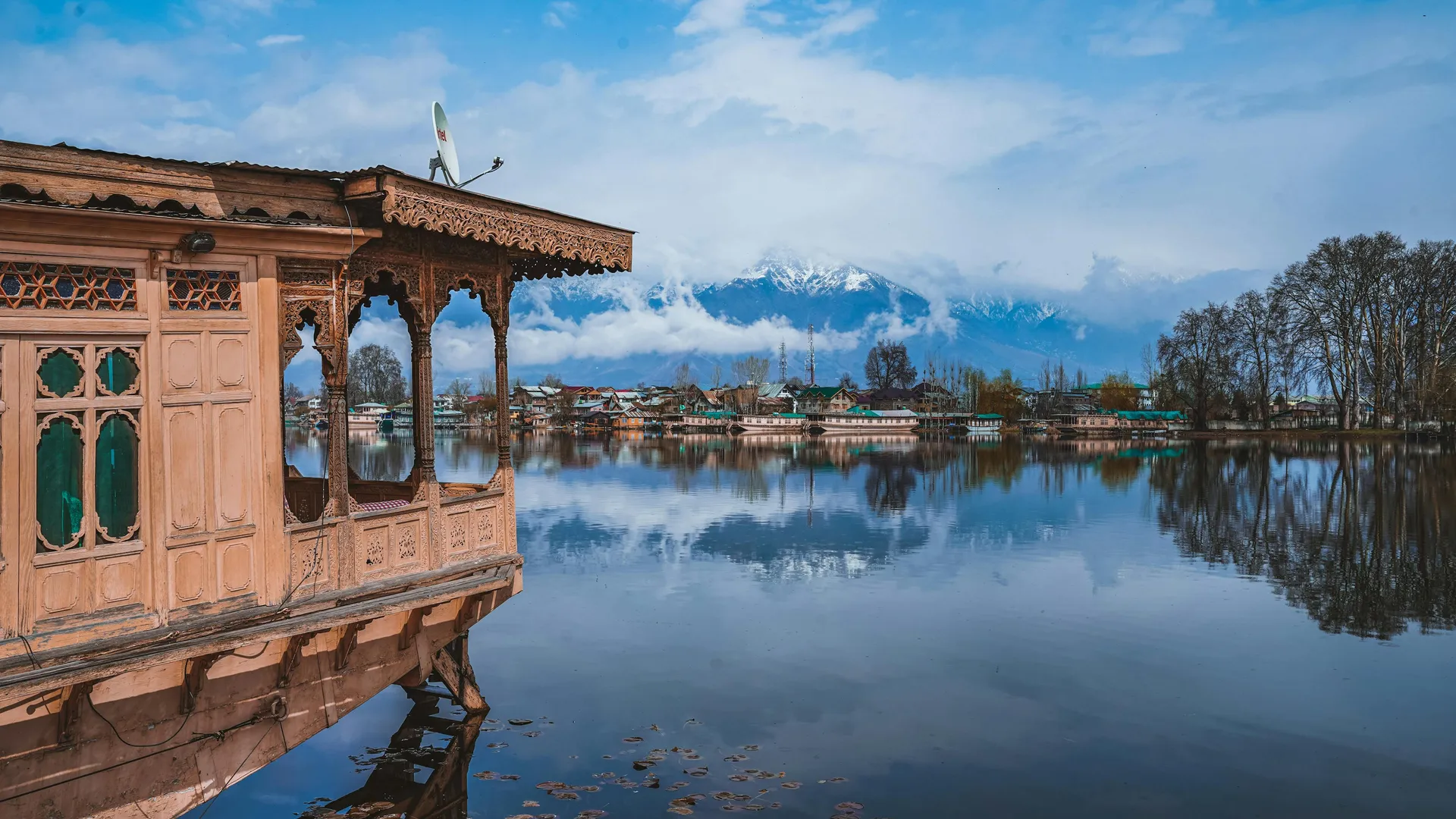 Houseboat on Dal Lake with mountain backdrop